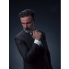 Portrait of a successful stylish elegant senior businessman with a grey beard and casual business clothes confident in photo studio isolated on dark background gesturing with hands. High-quality photo