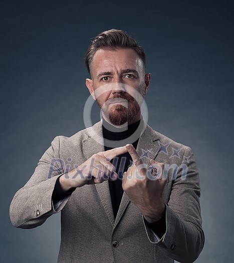 Portrait of a stylish elegant senior businessman with a beard and casual business clothes in photo studio isolated on dark background gesturing with hands. High quality photo Portrait of a stylish elegant senior businessman with a beard and casual business clothes in photo studio isolated on dark background gesturing with hands. High quality photo