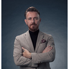 Portrait of a stylish elegant senior businessman with a beard and casual business clothes in photo studio isolated on dark background gesturing with hands. High quality photo