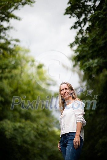 Portrait of a relaxed middle aged woman outdoors, looking happy, enjoying the life