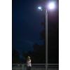 Young woman disturbed by harmful, cold, blue light of LED light in an urban environement (blue light messing up the natural human circadian rhytm)