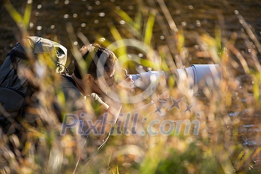 Senior man devoting time to his favorite hobby - photography - taking photos outdoor with his digital camera/DSLR and a big telephoto lens Senior man devoting time to his favorite hobby - photography - taking photos outdoor with his digital camera/DSLR and a big telephoto lens