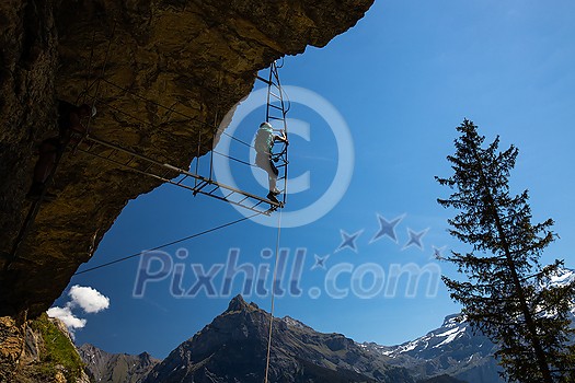 Young people on a via ferrata route in Swiss Alps Young people on a via ferrata route in Swiss Alps