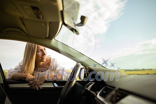 Pretty middle aged woman at the steering wheel of her car