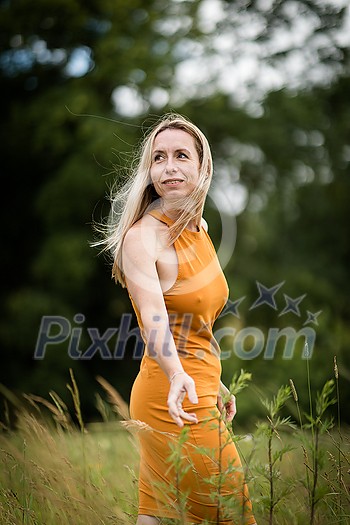 Portrait of a relaxed middle aged woman outdoors, looking happy, enjoying the life