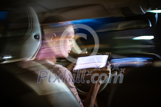 Young female driver playing with her cellphone instead of paying attention to driving startled in a potentially dangerous situation - Road safety concept