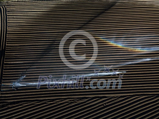Intense agriculture fiekd being irrigatedwith huge amounts of water on a hot summer day - aerial image Intense agriculture fiekd being irrigatedwith huge amounts of water on a hot summer day - aerial image
