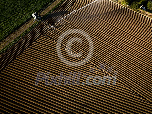 Intense agriculture fiekd being irrigatedwith huge amounts of water on a hot summer day - aerial image Intense agriculture fiekd being irrigatedwith huge amounts of water on a hot summer day - aerial image