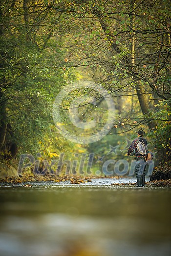 Fly fisherman fly fishing on a splendid mountain river Fly fisherman fly fishing on a splendid mountain river
