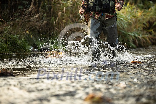 Close-up view of the hands of a fly fisherman holding a lovely trout while fly fishing on a splendid mountain river Close-up view of the hands of a fly fisherman holding a lovely trout while fly fishing on a splendid mountain river