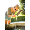 Young woman drinking water from a fountain