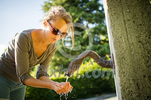 Young woman drinking water from a fountain Young woman drinking water from a fountain