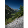 Pretty, female climber on a via ferrata - climbing on a rock in Swiss Alps