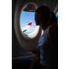 Young woman looking out of the window during a flight on a commercial aircraft