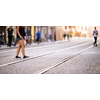 Blind woman walking on city streets, using her white cane to navigate the urban space better and to get to her destination safely