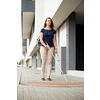 Blind woman walking on city streets, using her white cane