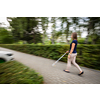 Blind woman walking on city streets, using her white cane