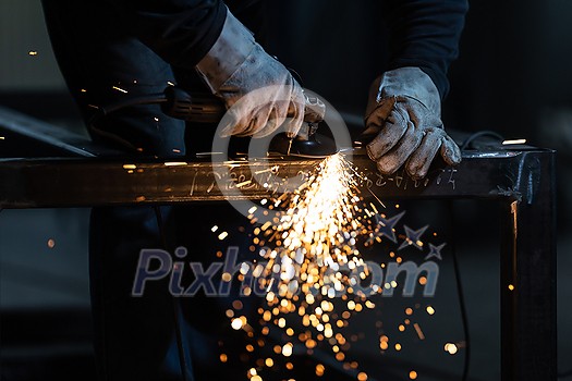 Man working on iron with grinder. Man at work. Sparkles and fire from grinder cutting. Grinder. Worker. Man working on iron with grinder. Man at work. Sparkles and fire from grinder cutting. Grinder. Worker.