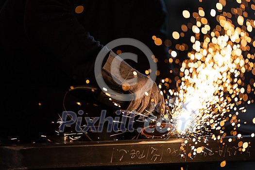 Man working on iron with grinder. Man at work. Sparkles and fire from grinder cutting. Grinder. Worker. Man working on iron with grinder. Man at work. Sparkles and fire from grinder cutting. Grinder. Worker.