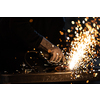 Man working on iron with grinder. Man at work. Sparkles and fire from grinder cutting. Grinder. Worker.