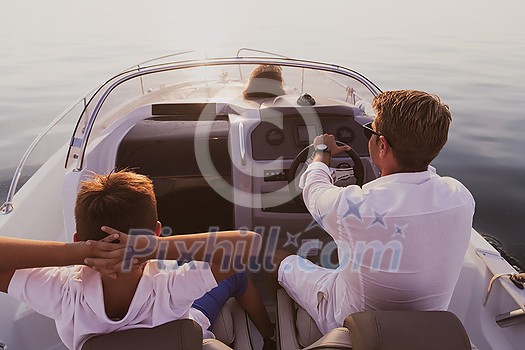 A senior couple in casual outfits with their son enjoy while riding a boat at sea at sunset. The concept of a happy family. Selective focus. High-quality photo