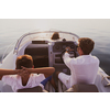 A senior couple in casual outfits with their son enjoy while riding a boat at sea at sunset. The concept of a happy family. Selective focus. High-quality photo