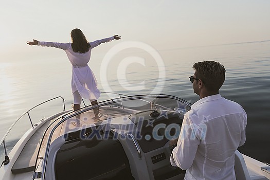 A senior couple in casual outfits with their son enjoy while riding a boat at sea at sunset. The concept of a happy family. Selective focus. High-quality photo