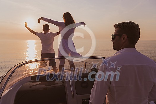 A senior couple in casual outfits with their son enjoy while riding a boat at sea at sunset. The concept of a happy family. Selective focus. High-quality photo