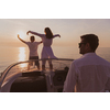 A senior couple in casual outfits with their son enjoy while riding a boat at sea at sunset. The concept of a happy family. Selective focus. High-quality photo
