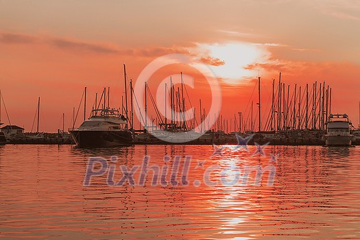 Sunrise on the seashore. In the silhouette of the ships in the harbor. Selective focus. High-quality photo