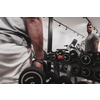 Struggling with age. Confident senior man exercising with dumbbells in the health club. Selective focus. High-quality photo