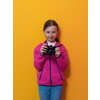 Little girl photographer isolated on yellow background smiling taking photos with a retro vintage camera. High quality photo