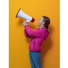 Funny little kid girl Screaming in megaphone over the yellow background in studio. People sincere emotions lifestyle concept. Mock up copy space. High quality photo