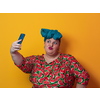 Trendy plus size woman taking selfie photo by smartphone over yellow Fortuna gold background smiling with an idea or question pointing finger with a happy face. High quality photo
