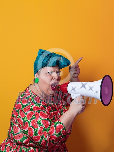 Funny plus size woman posing isolated on yellow background studio portrait. Overweight lady screaming in a megaphone. People emotions lifestyle concept. Mock up copy space. High quality photo Funny plus size woman posing isolated on yellow background studio portrait. Overweight lady screaming in a megaphone. People emotions lifestyle concept. Mock up copy space. High quality photo