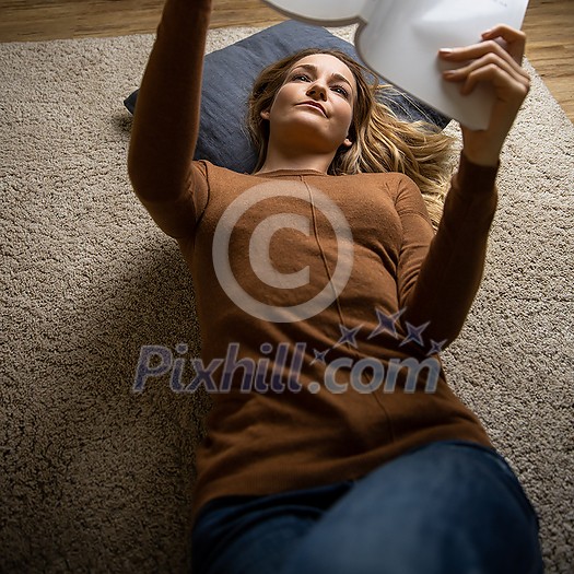 Pretty, young woman using her smart phone at home