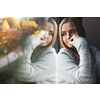 Depressed and anxious young woman sitting by a large window, feeling blue, sad, uncertain