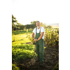 Senior gardener gardening in his permaculture garden - holding a spade