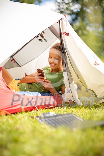 Cell phone charging with a solar charger in a tent during an outdoor trip