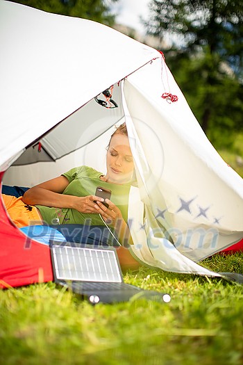 Cell phone charging with a solar charger in a tent during an outdoor trip Cell phone charging with a solar charger in a tent during an outdoor trip