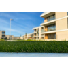 Modern and new apartment building. Multistoried modern, new and stylish living block of flats. Selective DOF, focus on the grass with blurred buildings in the background (ample copy space)