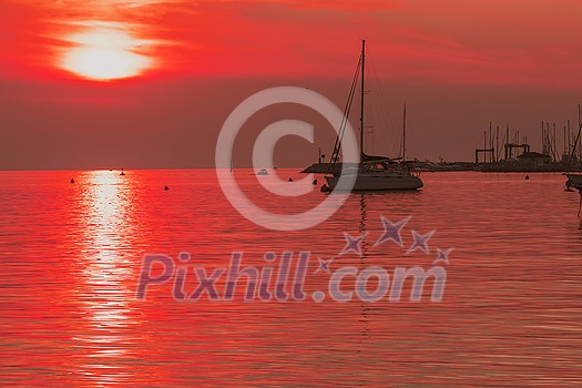 Sunrise on the seashore. In the silhouette of the ships in the harbor. Selective focus. High-quality photo