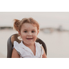 A portrait of a smiling little girl sitting in a bicycle seat. Selective focus. High-quality photo