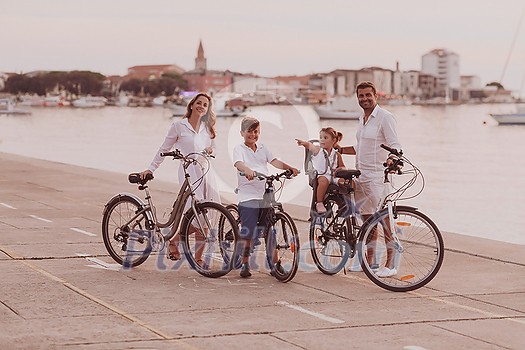 The happy family enjoys a beautiful morning by the sea riding a bike together and spending time together. The concept of a happy family. High-quality photo The happy family enjoys a beautiful morning by the sea riding a bike together and spending time together. The concept of a happy family. High-quality photo