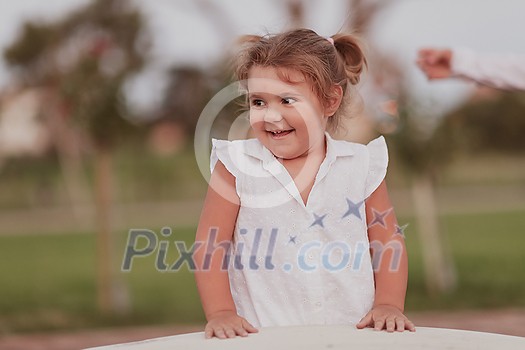 A little girl in modern summer clothes playing in the park in summer. Selective focus. High-quality photo A little girl in modern summer clothes playing in the park in summer. Selective focus. High-quality photo