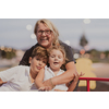 An older grandmother is playing with her grandchildren in a park at sunset. Selective focus. High-quality photo