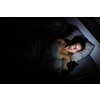 Pretty, middle-aged woman using her cell phone in bed at night - unhealthy  blue light exposure