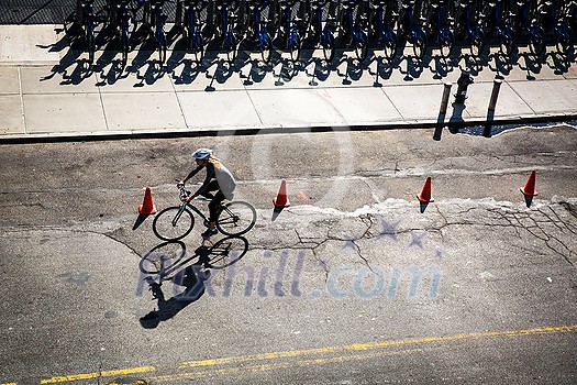 New York City street with rental bikes and a cyclist on the road see from above New York City street with rental bikes and a cyclist on the road see from above