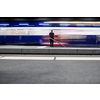 People in a trainstation with motion blurred trains moving fast (color toned image)