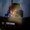 Female police officer in a call center, listening carefully to an emergency call from a person in distress